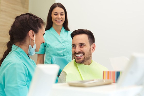 Man smiling at dental assistant during appointment