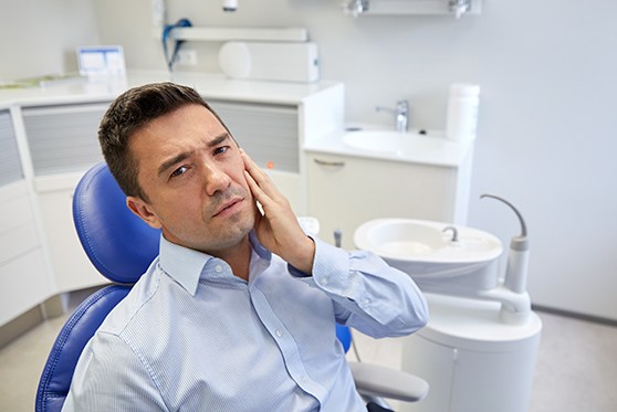 Man with tooth pain visiting emergency dentist in Bedford, VA