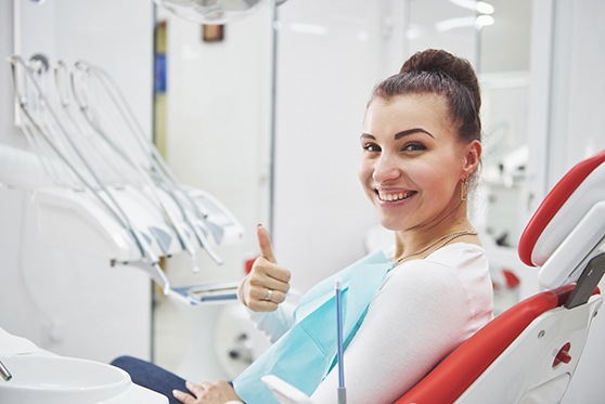 Female dental patient giving a thumbs up
